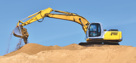 Construction equipment on sand dune picking up sand