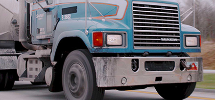 Lower view of a truck on a highway with blue cab