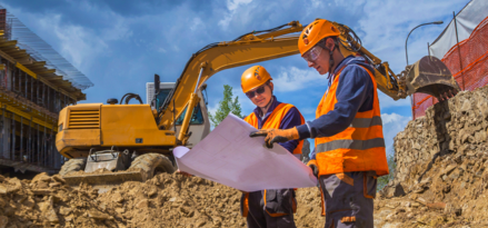 Deux ouvriers sur un chantier regardant un plan