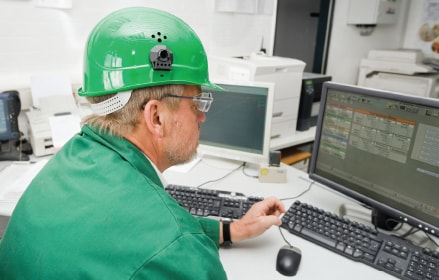 Homme en casque de chantier sur ordinateur